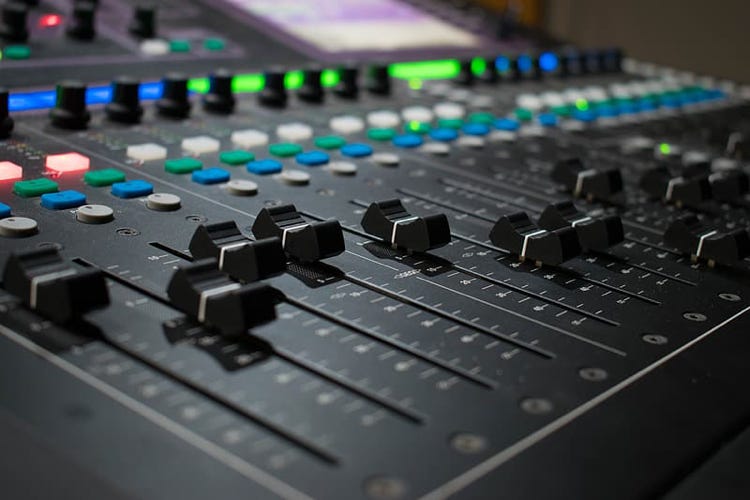 Close-up of the sliders on a complex audio mixer